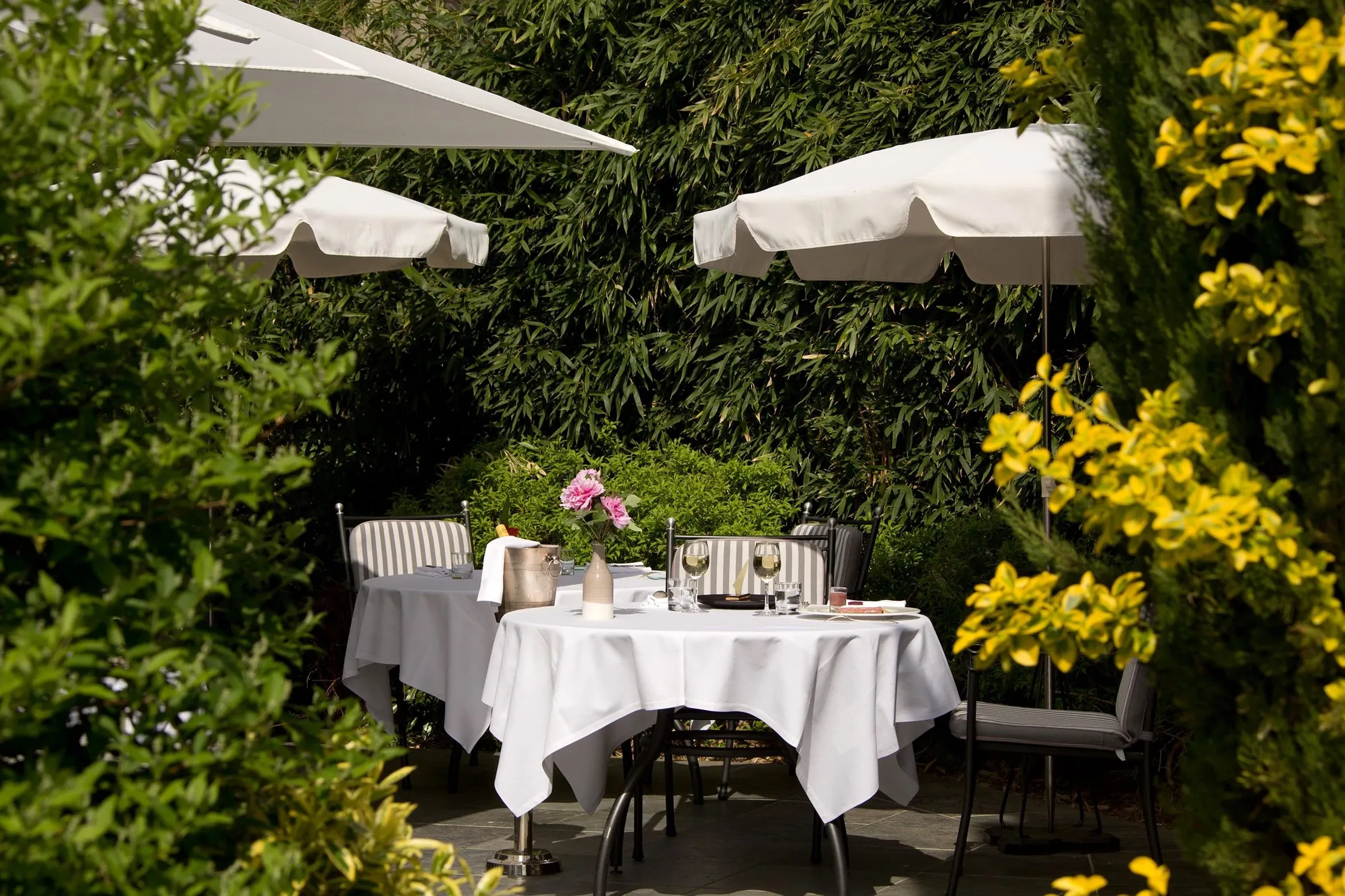 Terrasse avec tables et chaises sous parasols.