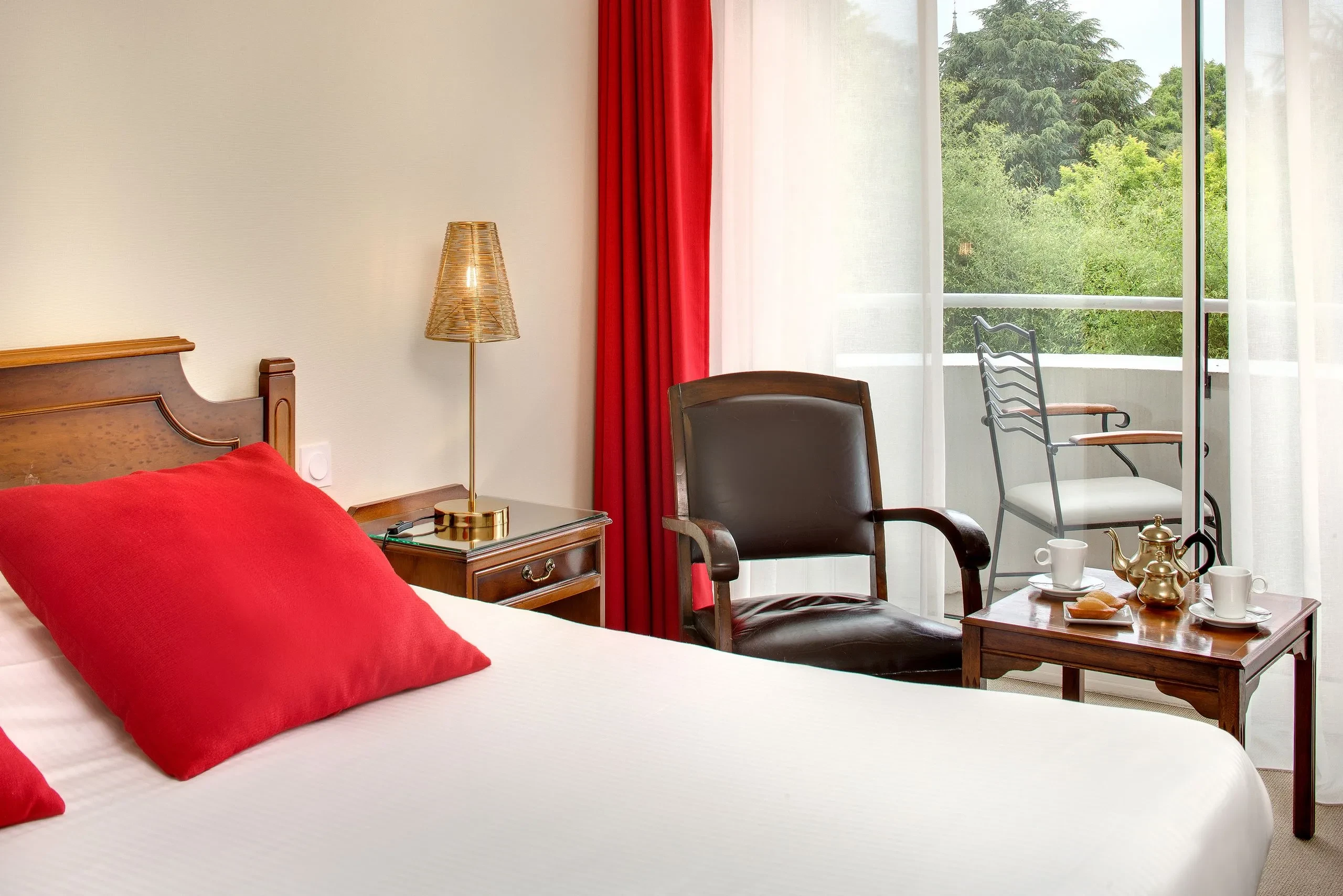 Chambre d'Hôtel à Sarthe avec balcon et fauteuil.