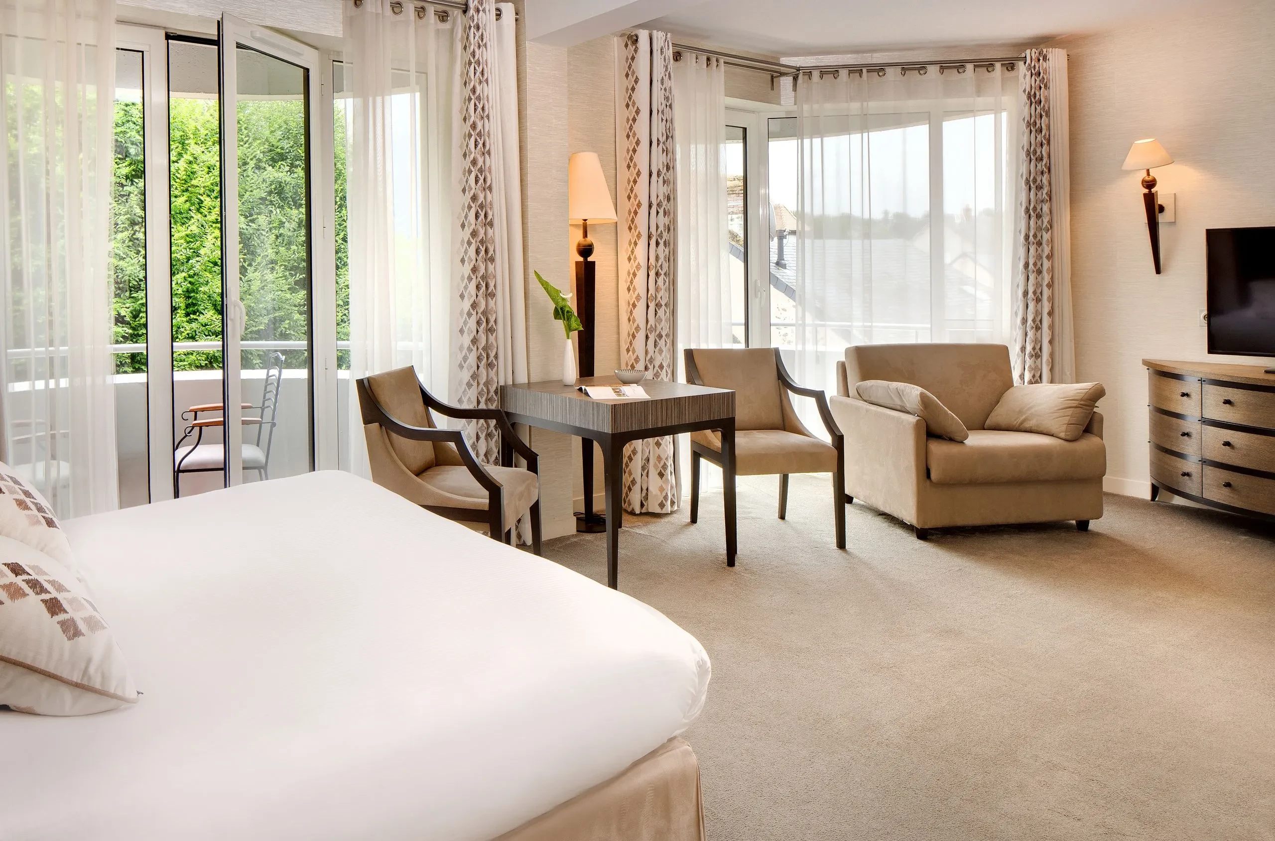 Chambre d'hôtel spacieuse avec balcon et mobilier moderne. Hôtel Sarthe