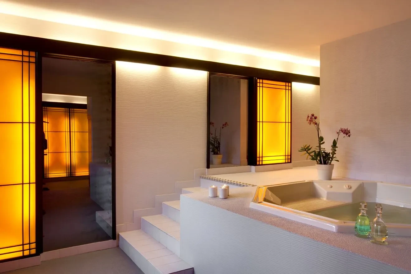 Salle de bain moderne avec spa et éclairage chaleureux.